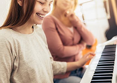 Daughter and mother playing piano